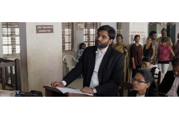Vivek Gomber (standing) as Vinay Vora in COURT. A film by Chaitanya Tamhane. A Zeitgeist Films release.